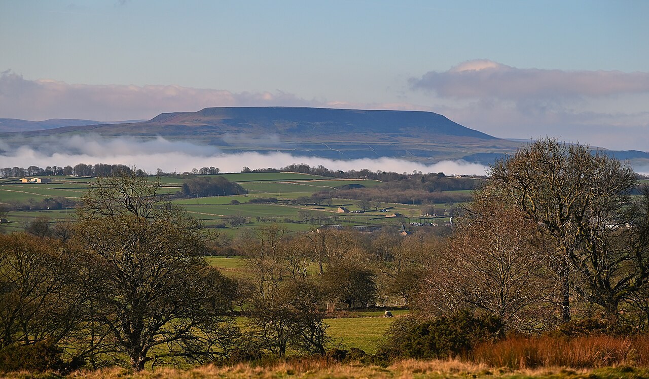 Low cloud over Penhill and green fields in the Yorkshire Dales.